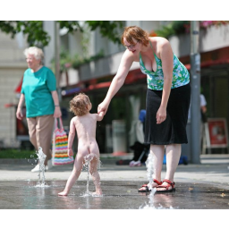 19.06.2007, eine junge Mutter und ihr Kind erfrischen sich an einem Wasserspiel auf der Hauptstraße in Dresden

 
