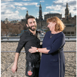 14.12.2017, die Sächsische Integrationsministerin Petra Köpping mit ihrem Flüchtling aus Syrien Khaled Tabanja auf dem Balkon Landtags-Restaurants Chiaveri fotografiert, im Hintergrund die Dresdner Stadtsilhouette 